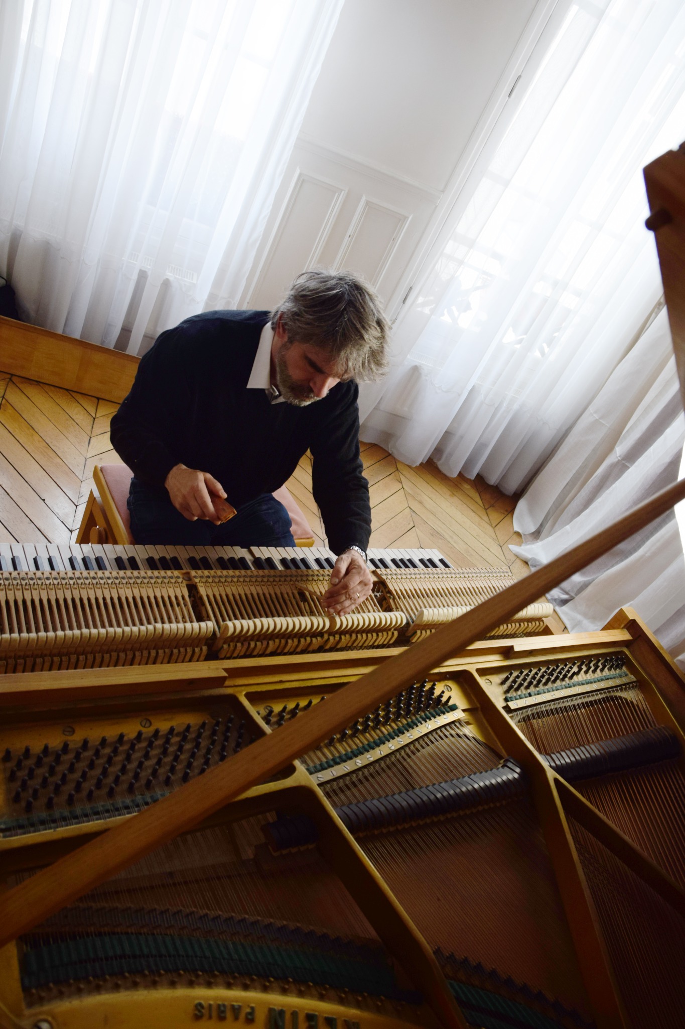 Boris Vallas intervenant sur la mécanique d’un piano à queue